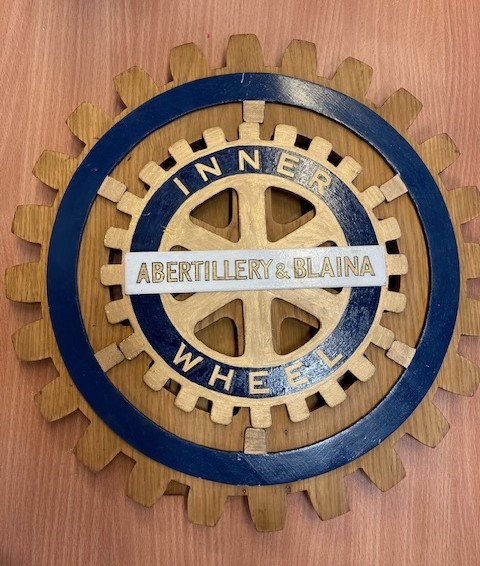 Photo of Inner Wheel club wooden carved logo